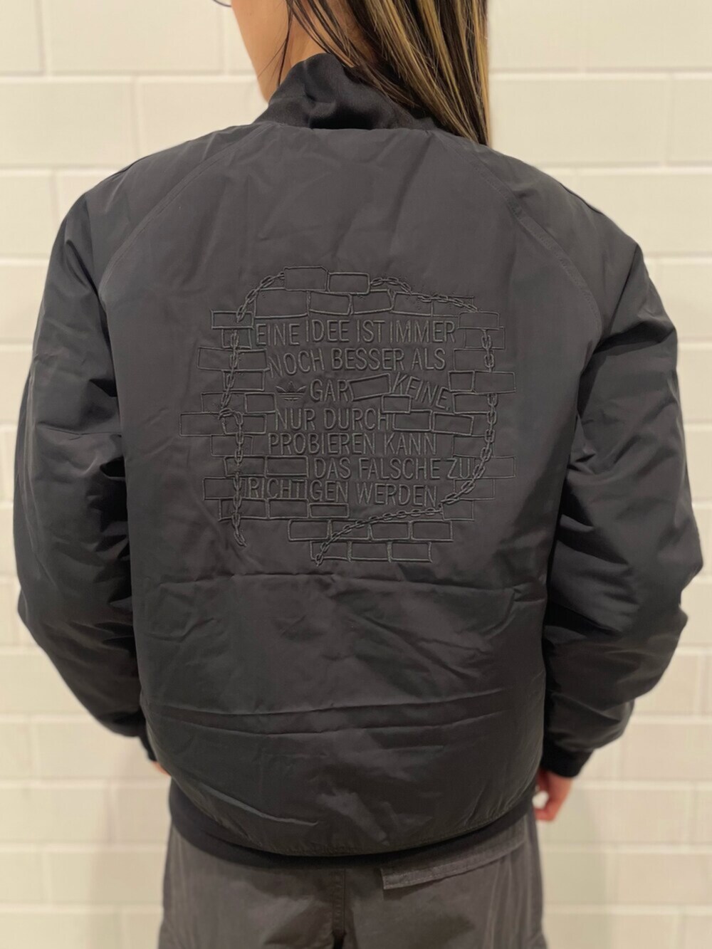 ブラック系のTシャツ/カットソー、ブラック系のブルゾン、グレー系のその他パンツを着用したレディースの冬コーディネートの5枚目の写真