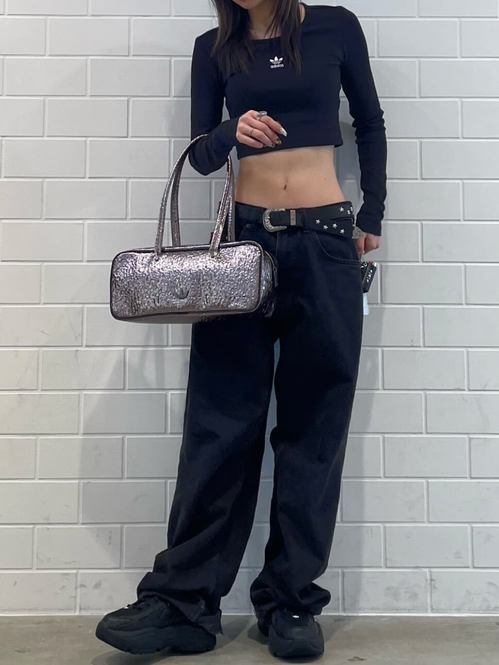 ブラック系のスニーカー、ブラック系のTシャツ/カットソー、グレー系のショルダーバッグを着用したレディースの冬コーディネートの2枚目の写真