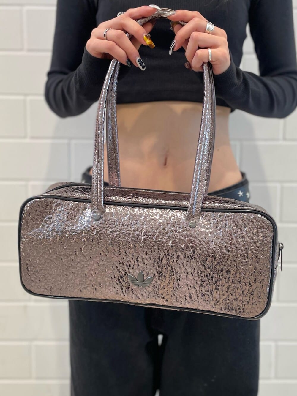 ブラック系のスニーカー、ブラック系のTシャツ/カットソー、グレー系のショルダーバッグを着用したレディースの冬コーディネートの5枚目の写真