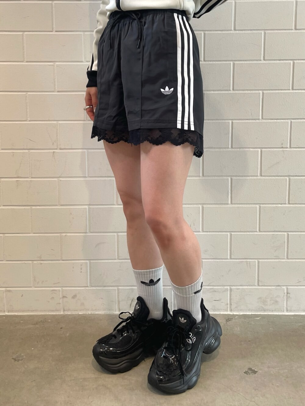 ブラック系のショルダーバッグ、ブラック系のスニーカー、ホワイト系のトップスを着用したレディースの春コーディネートの5枚目の写真