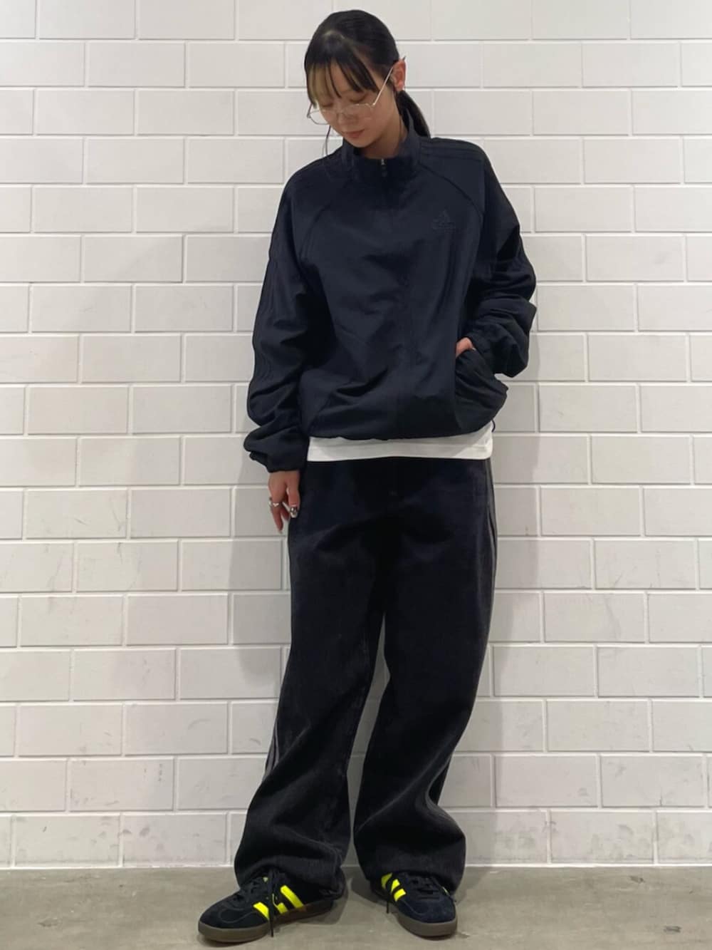 ブラック系のデニムパンツ、ブラック系のスニーカー、ブラック系のジャージを着用したレディースの冬コーディネートの3枚目の写真