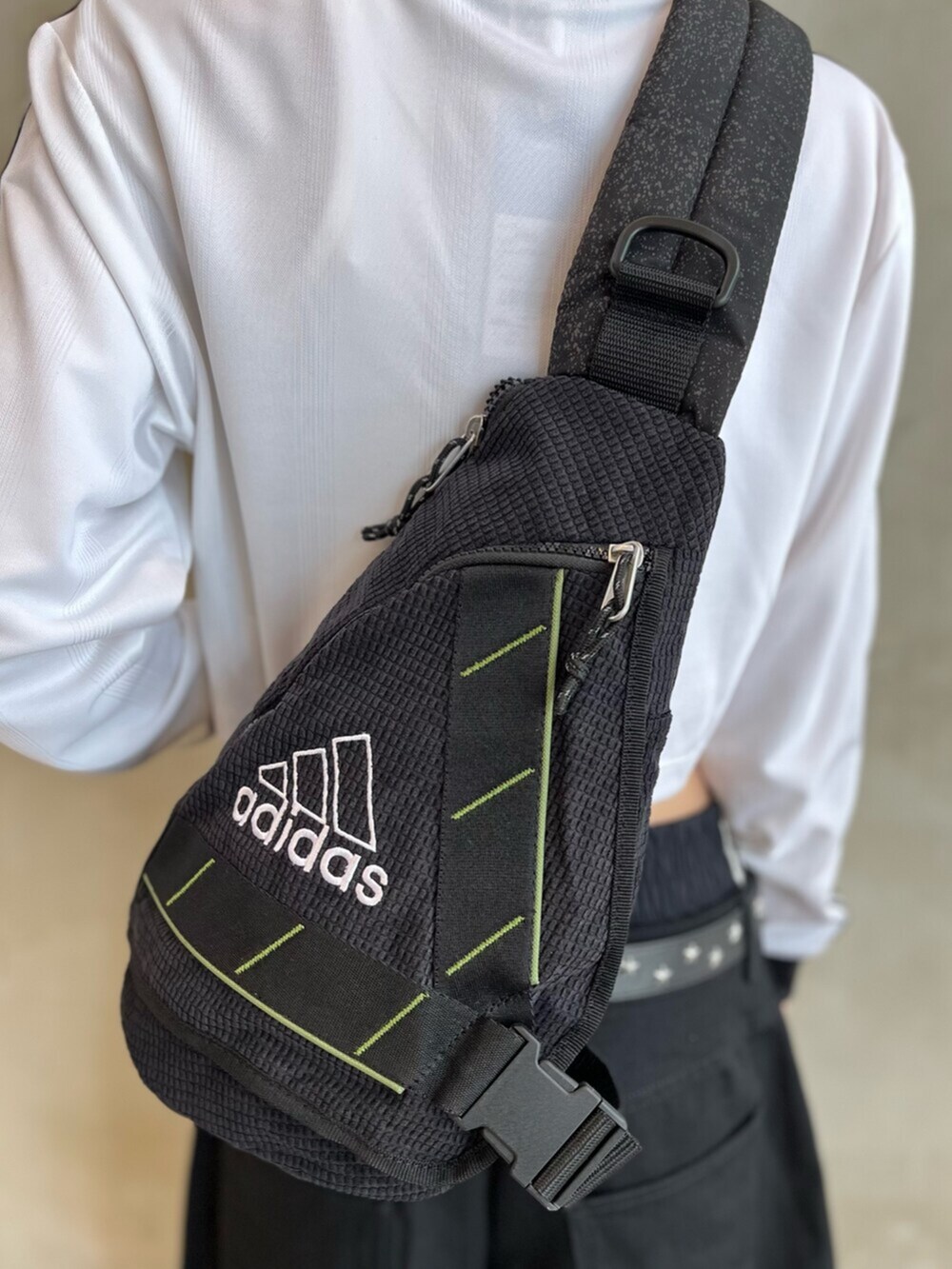 ブラック系のパンツ、ブラック系のスニーカー、ブラック系のバックパック/リュックを着用したレディースの夏コーディネートの4枚目の写真