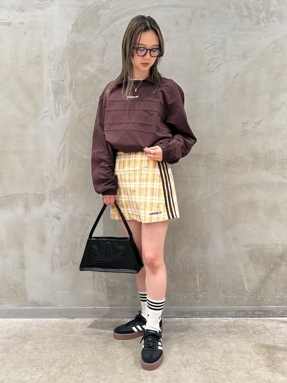 ブラウン系のTシャツ/カットソー、ベージュ系のスカート、ブラック系のショルダーバッグを着用したレディースの秋コーディネートの3枚目の写真