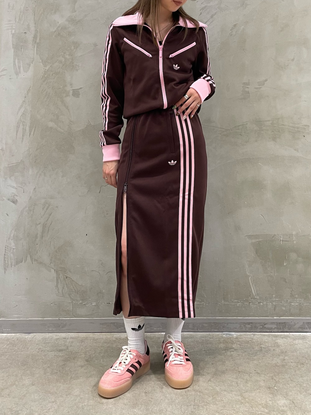 ピンク系のスニーカー、ブラウン系のスカート、ブラウン系のジャージを着用したレディースの秋コーディネートの2枚目の写真