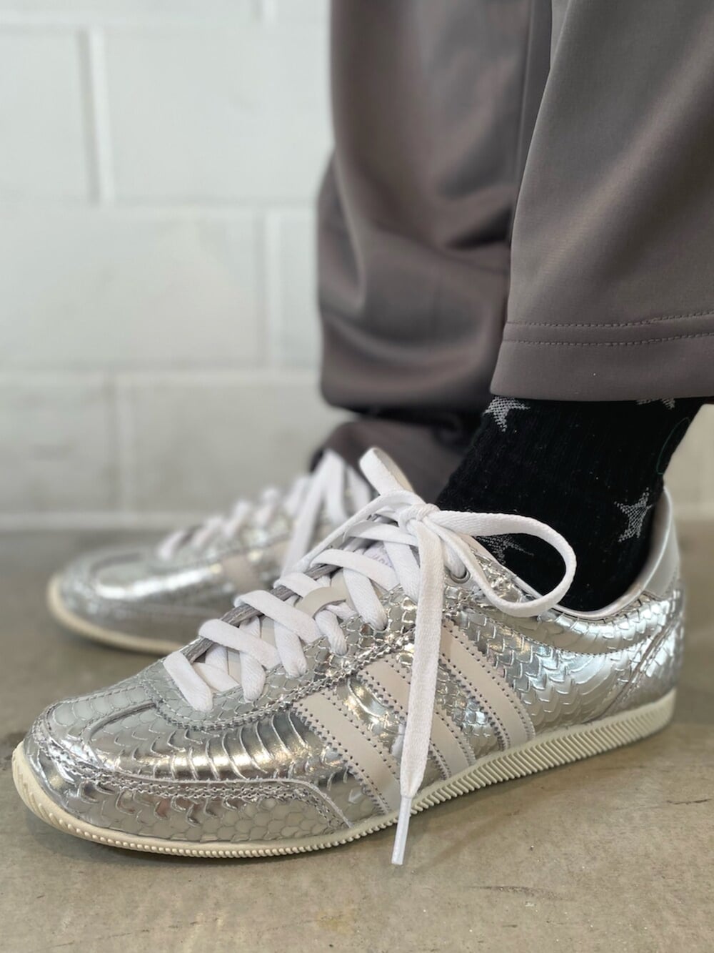 シルバー系のスニーカー、ブルー系のデニムジャケット、グレー系のその他パンツを着用したレディースの春コーディネートの6枚目の写真