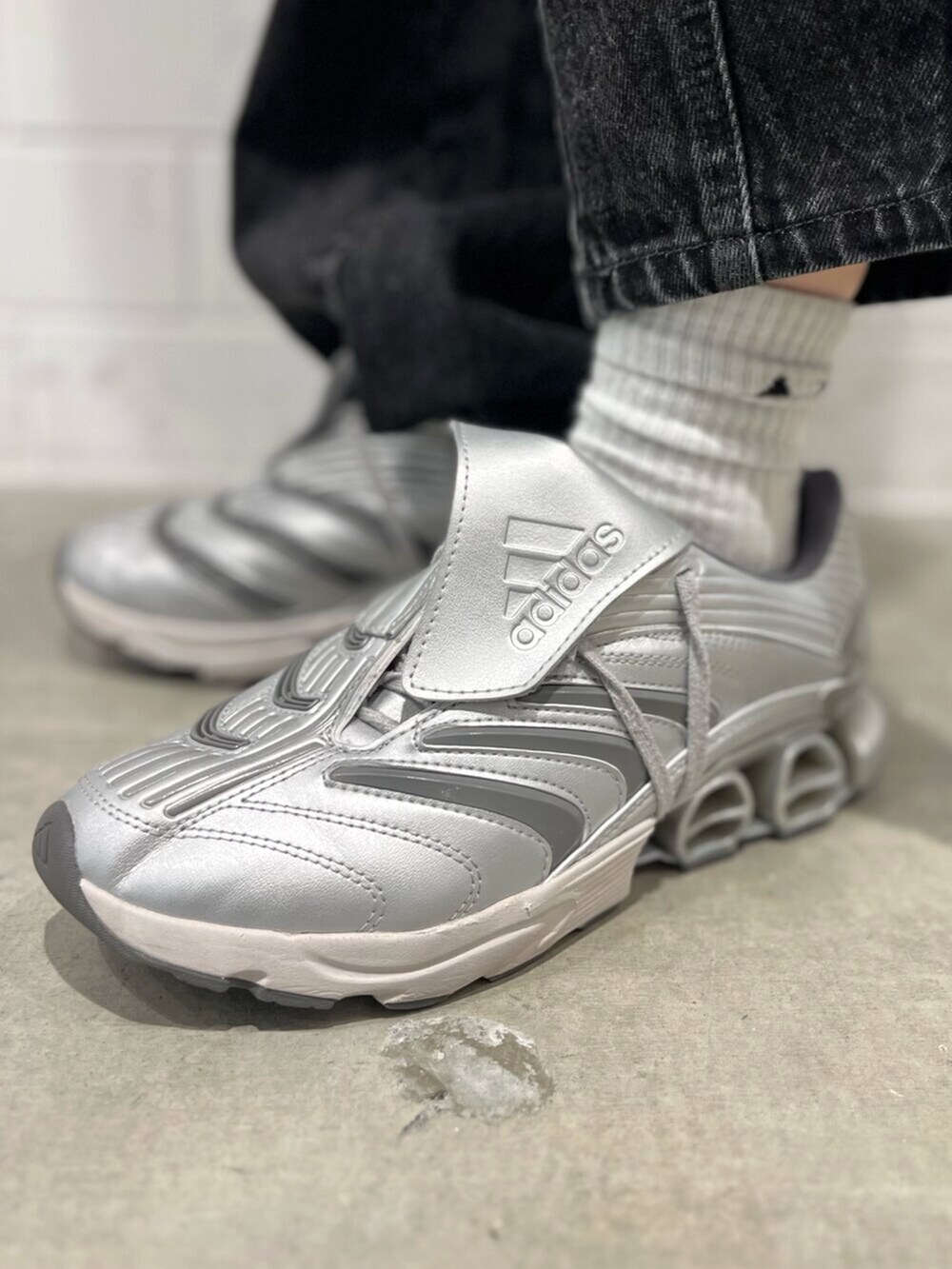 グレー系のシューズ、ブラック系のデニムパンツ、ベージュ系のブルゾンを着用したレディースの秋コーディネートの6枚目の写真