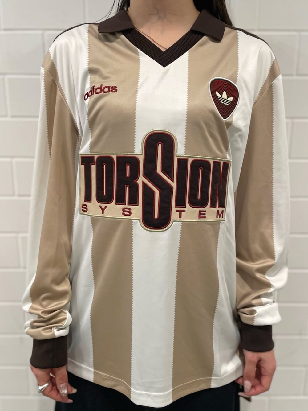 ホワイト系のTシャツ/カットソー、ブラウン系のスニーカー、ブルー系のショルダーバッグを着用したレディースの春コーディネートの3枚目の写真