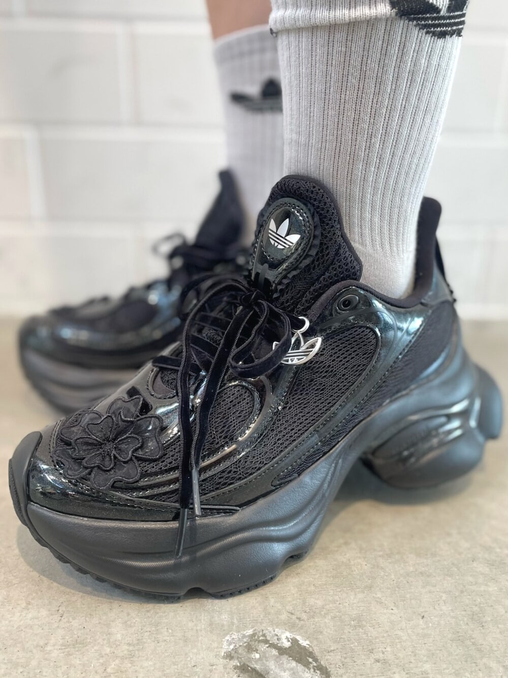 ブラック系のショルダーバッグ、ブラック系のスニーカー、ホワイト系のトップスを着用したレディースの春コーディネートの6枚目の写真