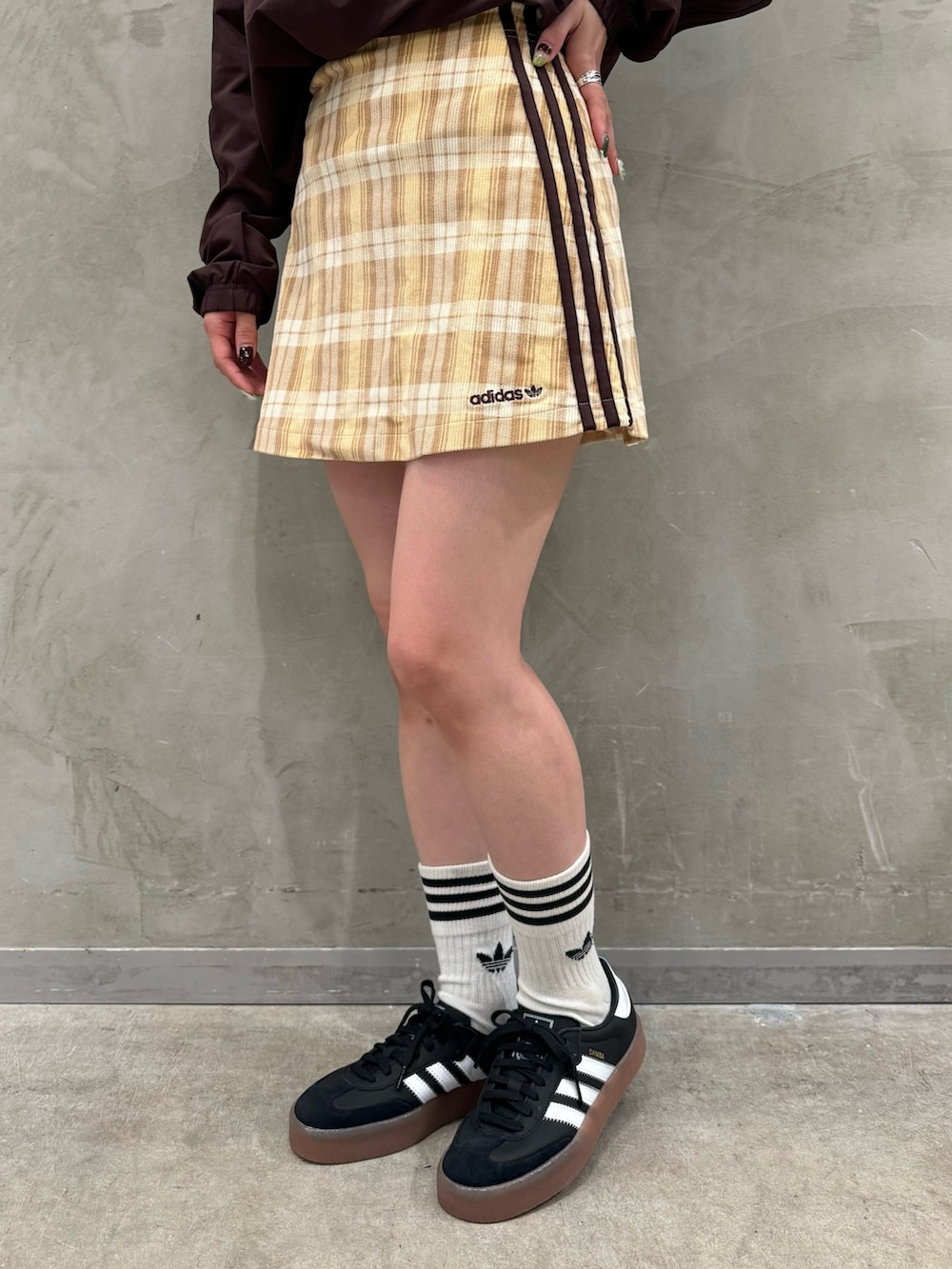 ブラウン系のTシャツ/カットソー、ベージュ系のスカート、ブラック系のショルダーバッグを着用したレディースの秋コーディネートの6枚目の写真