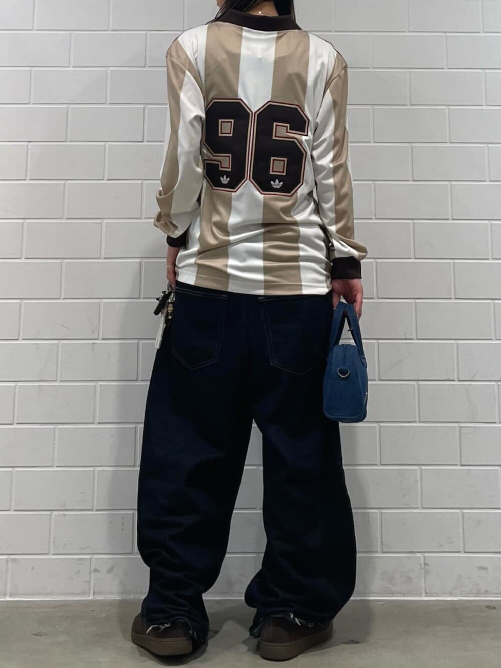 ホワイト系のTシャツ/カットソー、ブラウン系のスニーカー、ブルー系のショルダーバッグを着用したレディースの春コーディネートの2枚目の写真