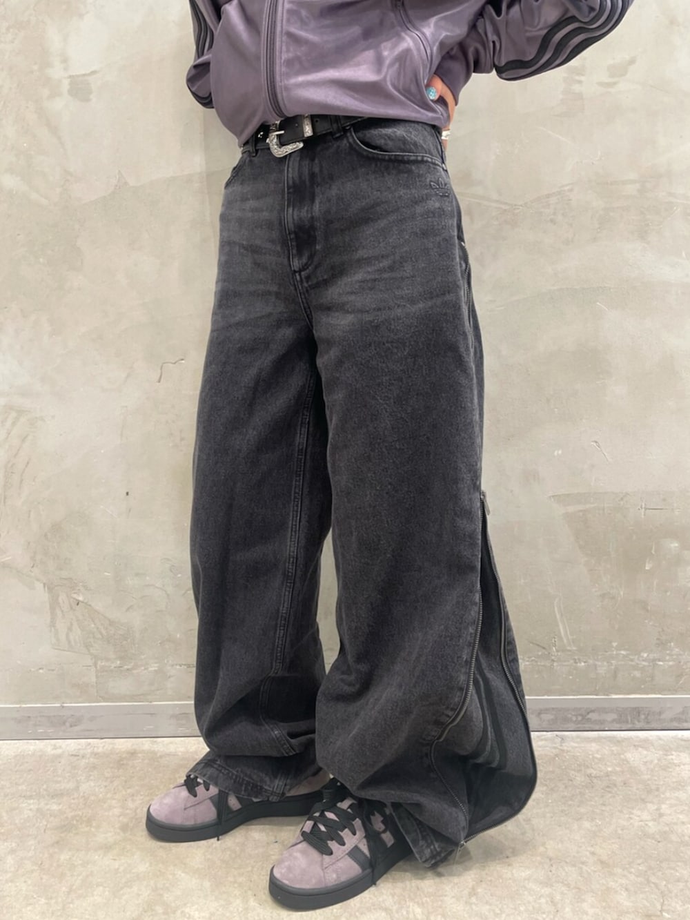 ブラウン系のスニーカー、グレー系のトップス、ブラック系のデニムパンツを着用したレディースの秋コーディネートの5枚目の写真