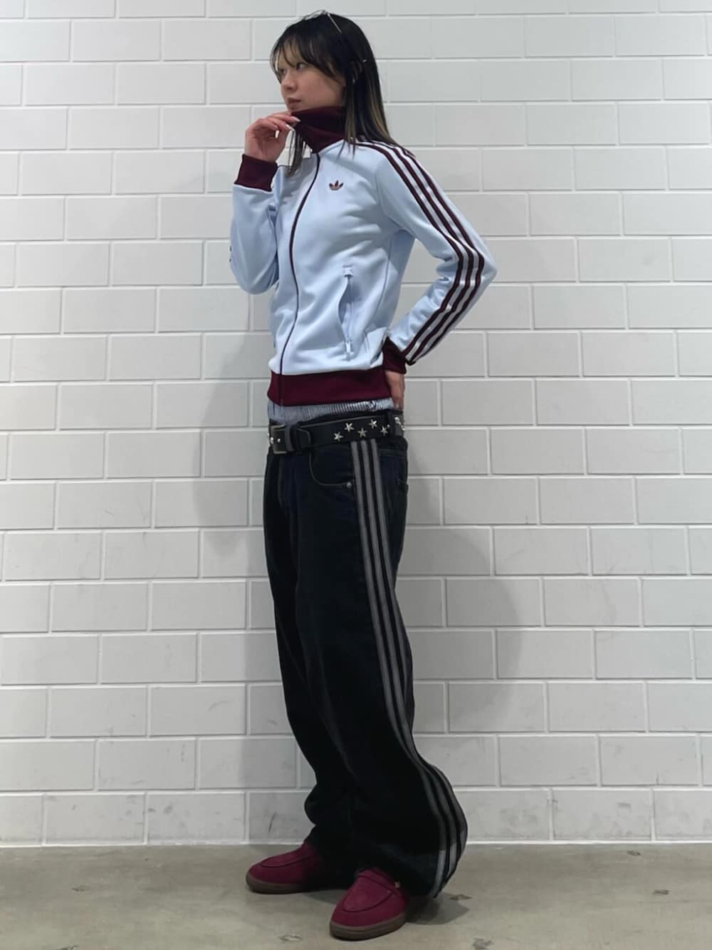 レッド系のスニーカー、ブルー系のトップス、ブラック系のデニムパンツを着用したレディースの春コーディネートの3枚目の写真