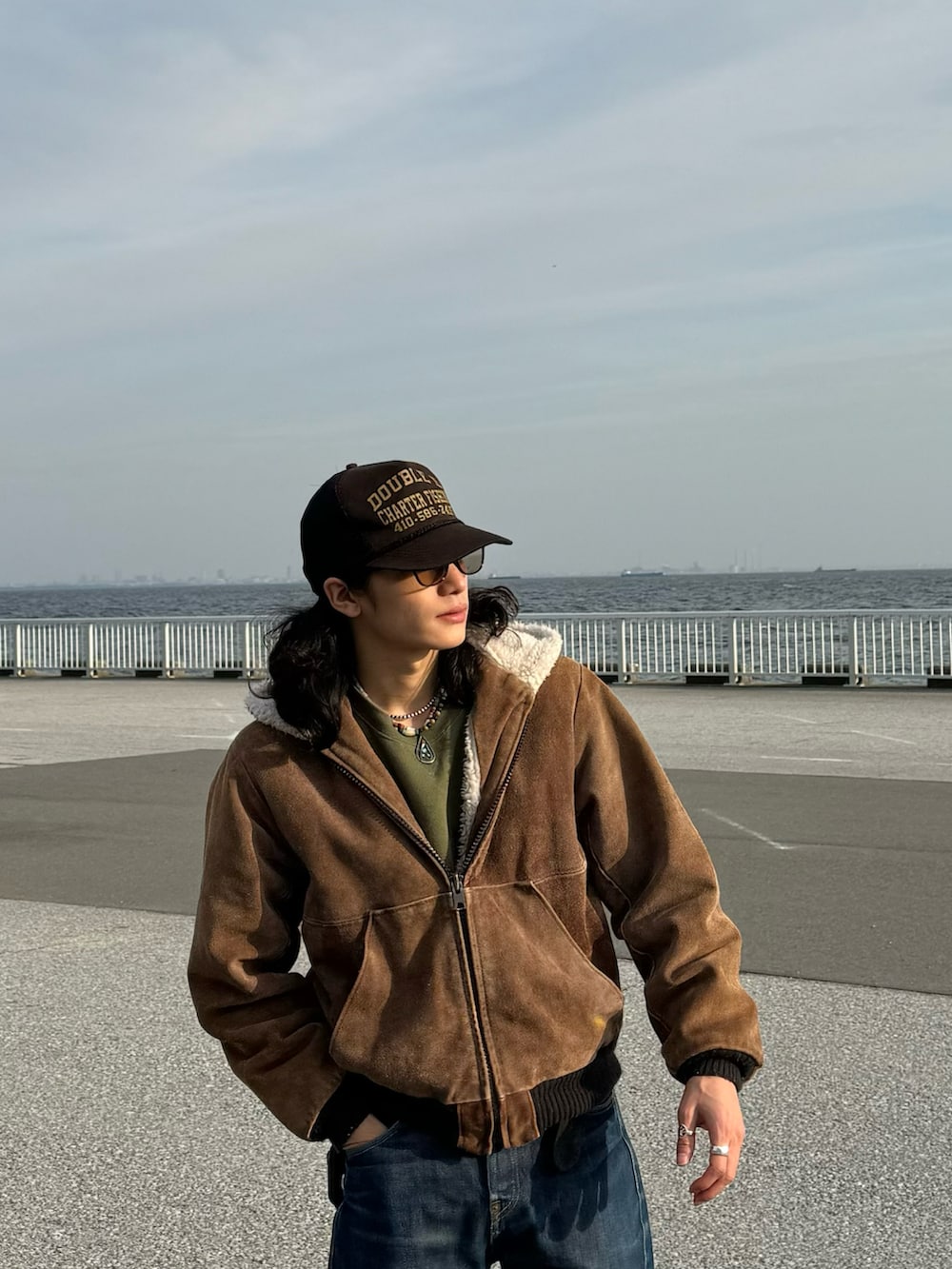 ブラック系のブーツ、ブルー系のデニムパンツ、ブラウン系のジャケット/アウターを着用したメンズの冬コーディネートの3枚目の写真