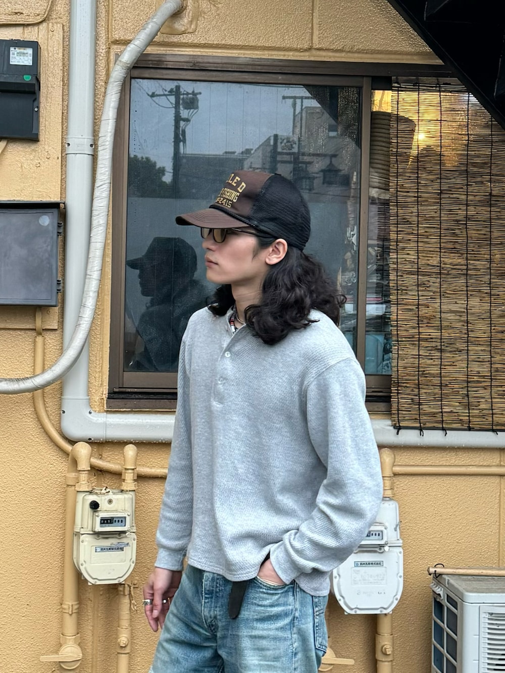 グレー系のTシャツ/カットソー、ブルー系のデニムパンツ、ブラック系のブーツを着用したメンズの春コーディネートの4枚目の写真