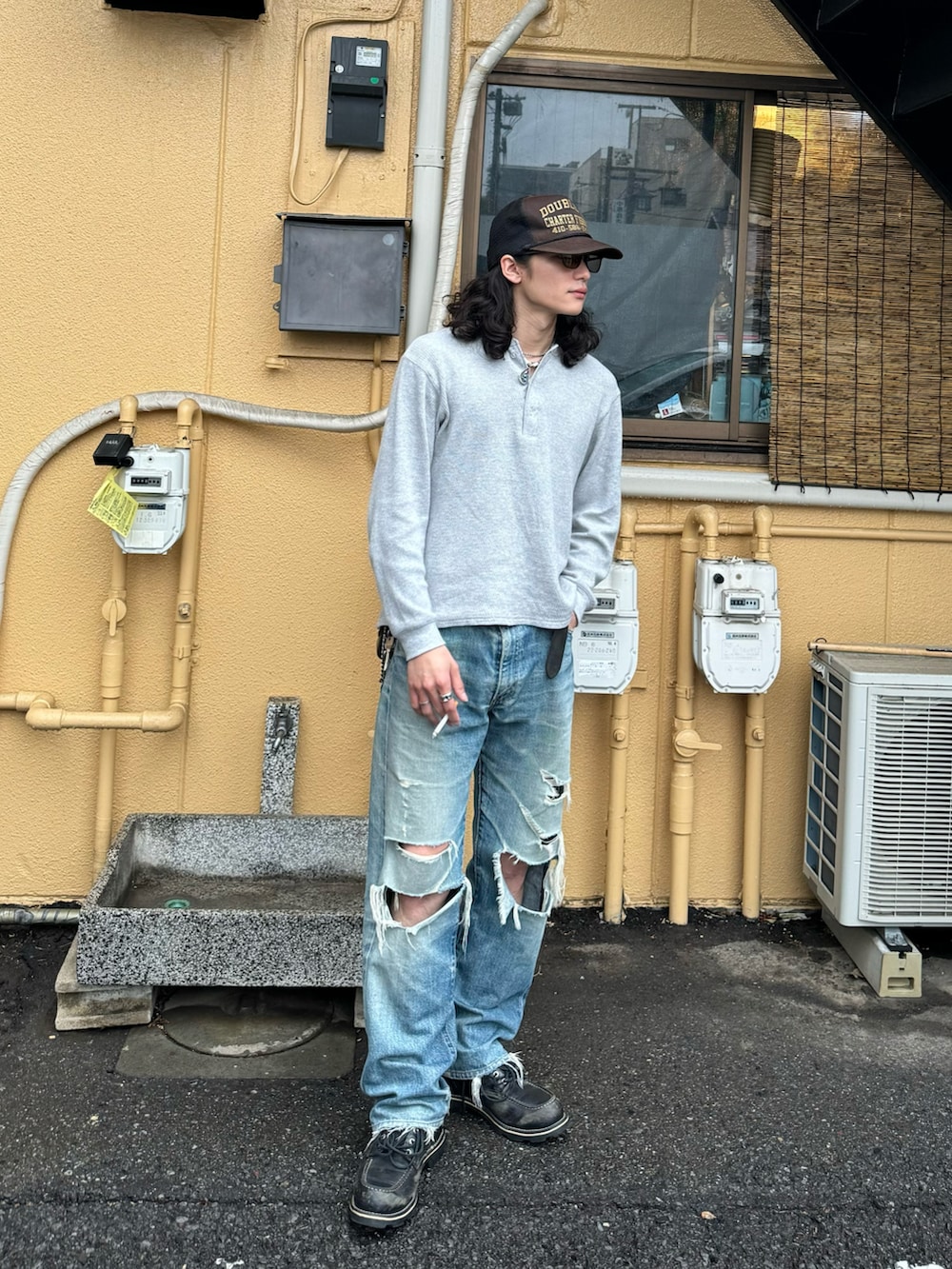 グレー系のTシャツ/カットソー、ブルー系のデニムパンツ、ブラック系のブーツを着用したメンズの春コーディネートの2枚目の写真