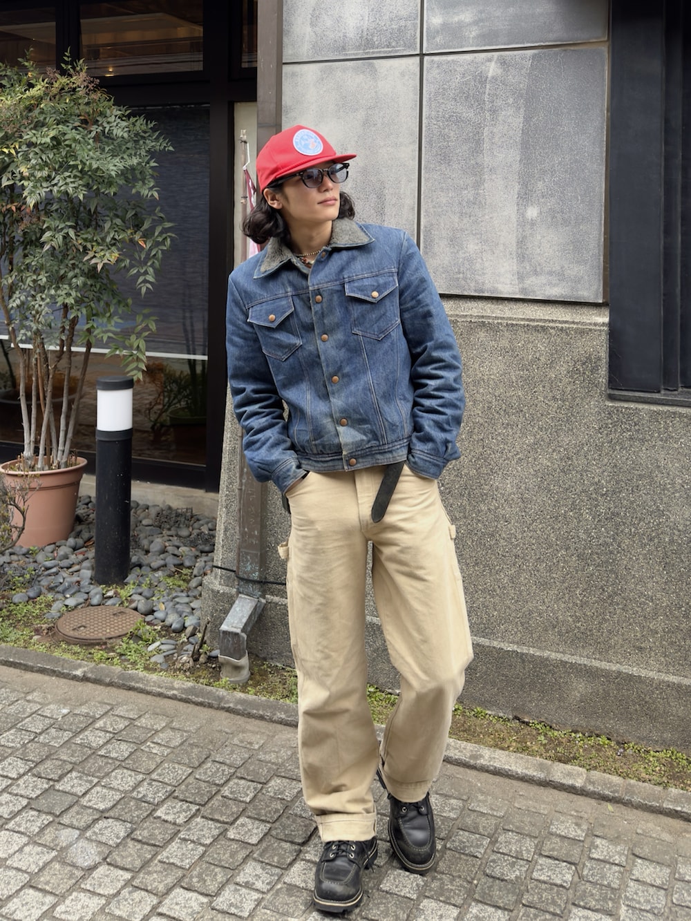 ブルー系のデニムジャケット、ベージュ系のチノパンツ、ブラック系のブーツを着用したメンズの冬コーディネートの2枚目の写真