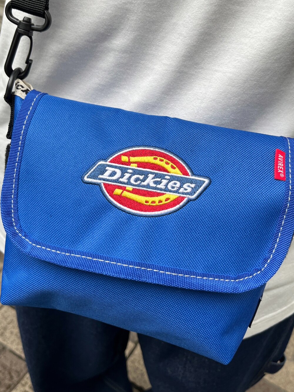 ブルー系のショルダーバッグ、ブルー系のパンツ、ホワイト系のTシャツ/カットソーを着用したメンズの春コーディネートの3枚目の写真