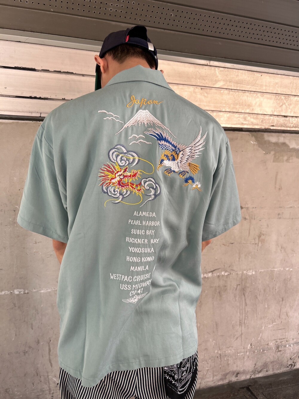 グリーン系のシャツ/ブラウス、その他のチノパンツ、ブルー系のキャップを着用したメンズの春コーディネートの2枚目の写真