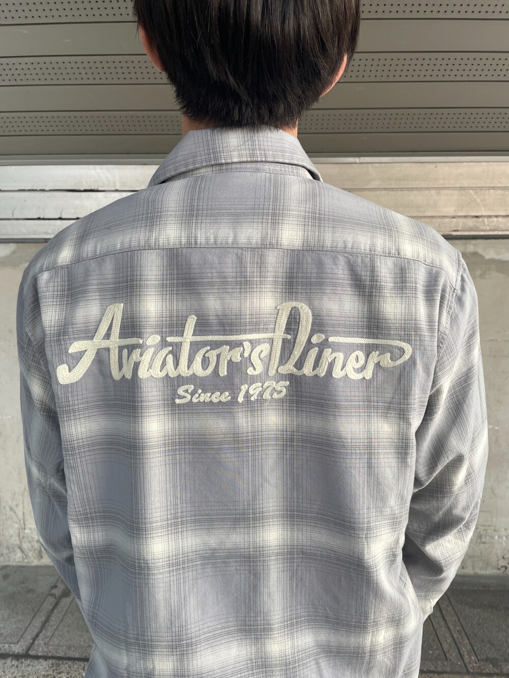 ブラック系のTシャツ/カットソー、グレー系のシャツ/ブラウス、ブラック系のチノパンツを着用したメンズの春コーディネートの2枚目の写真