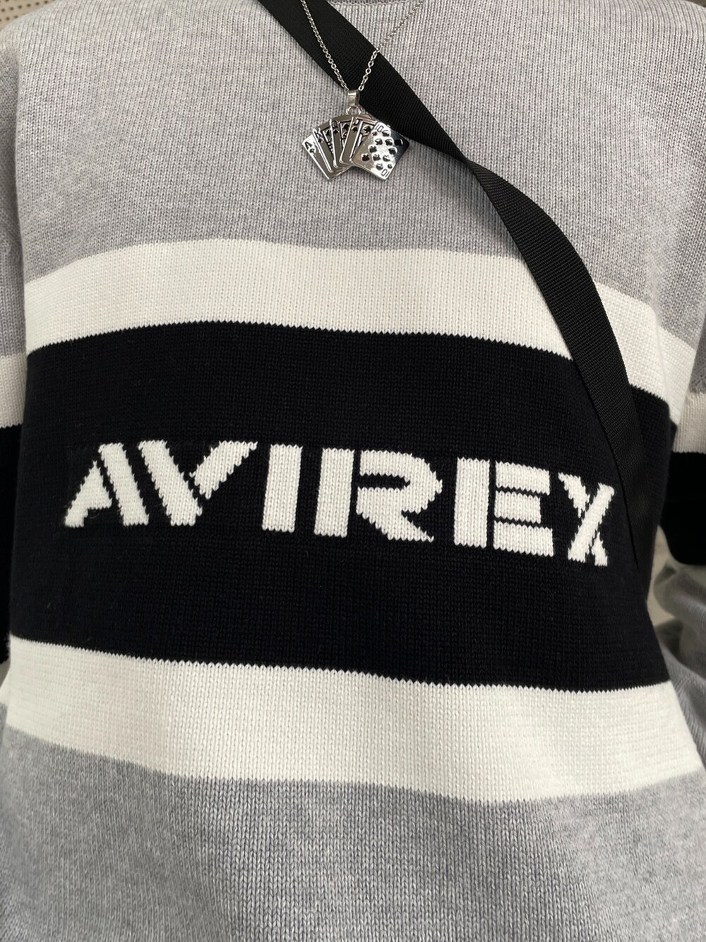 グレー系のニット/セーター、ブラック系のショルダーバッグ、ホワイト系のパンツを着用したメンズの冬コーディネートの2枚目の写真