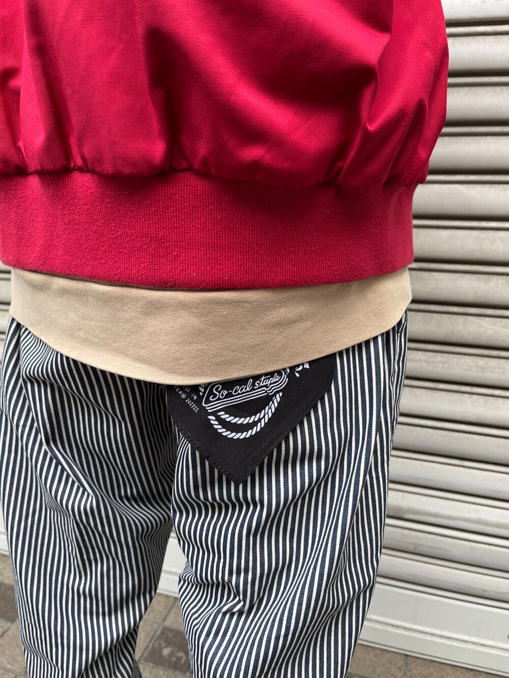 レッド系のミリタリージャケット、ブラック系のパンツを着用したメンズの冬コーディネートの3枚目の写真
