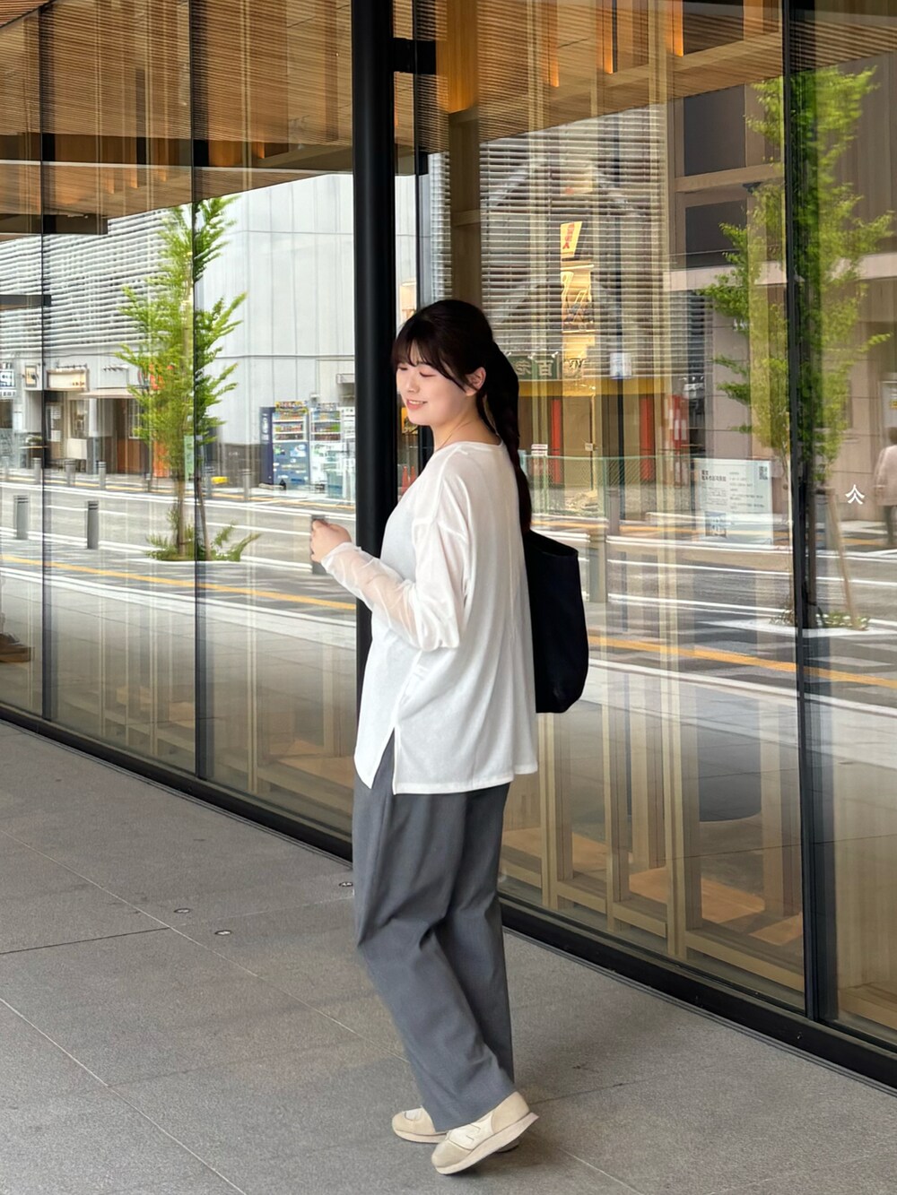 グレー系のパンツ、ホワイト系のTシャツ/カットソーを着用したレディースの春コーディネートの2枚目の写真