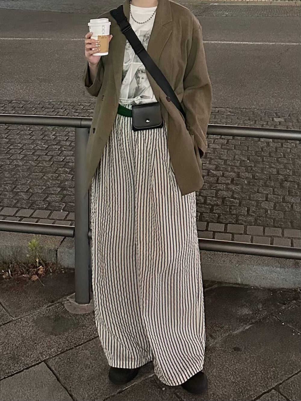 ブラウン系のその他アウター、ブラック系のショルダーバッグ、ホワイト系のTシャツ/カットソーを着用したレディースの春コーディネートの2枚目の写真