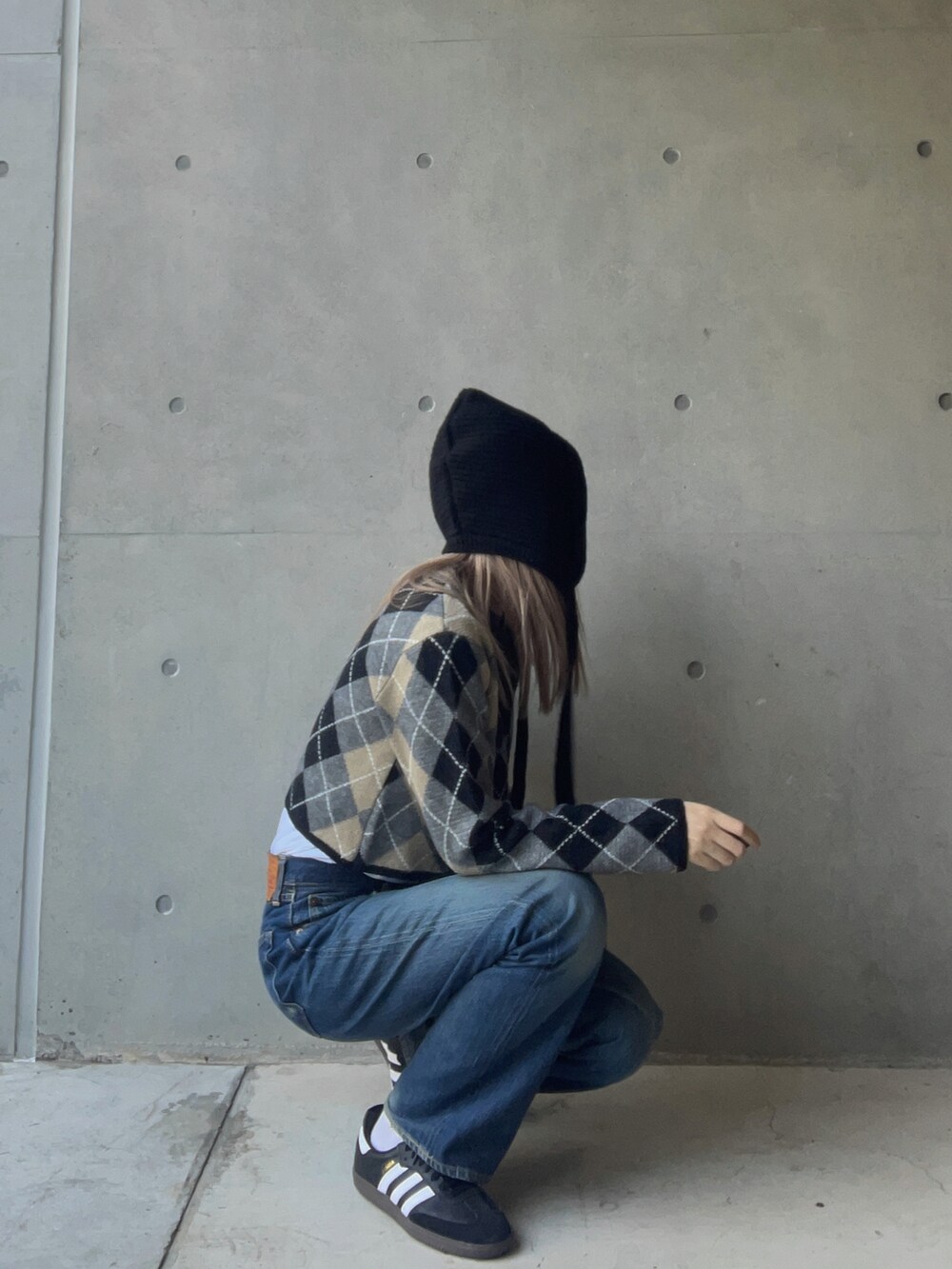 ブルー系のカーディガン/ボレロ、ブルー系のデニムパンツ、ブラック系のスニーカーを着用したレディースの冬コーディネートの2枚目の写真