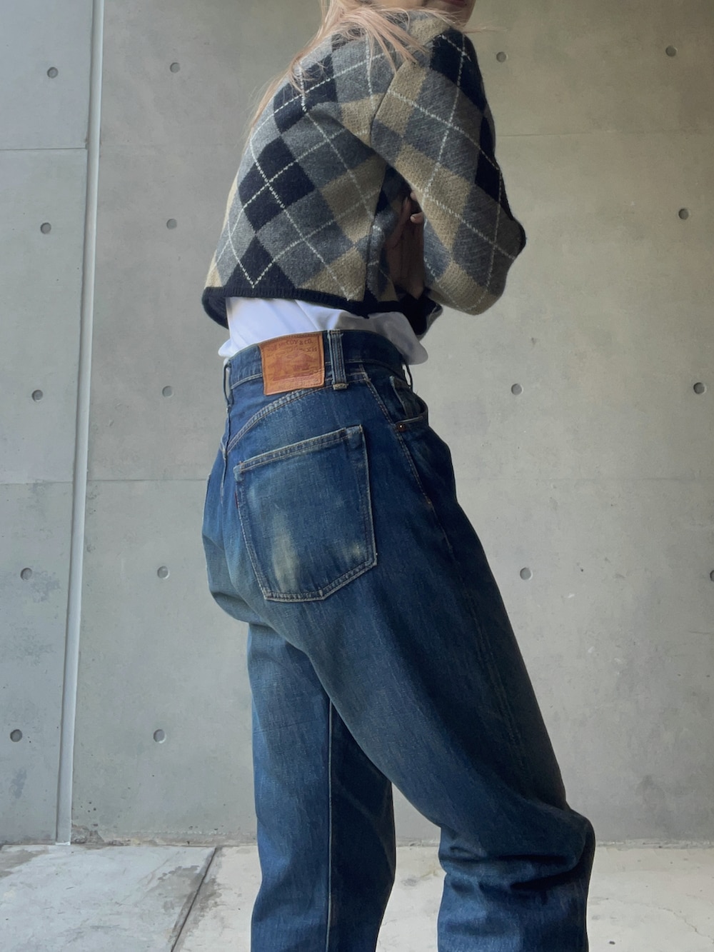 ブルー系のカーディガン/ボレロ、ブルー系のデニムパンツ、ブラック系のスニーカーを着用したレディースの冬コーディネートの3枚目の写真