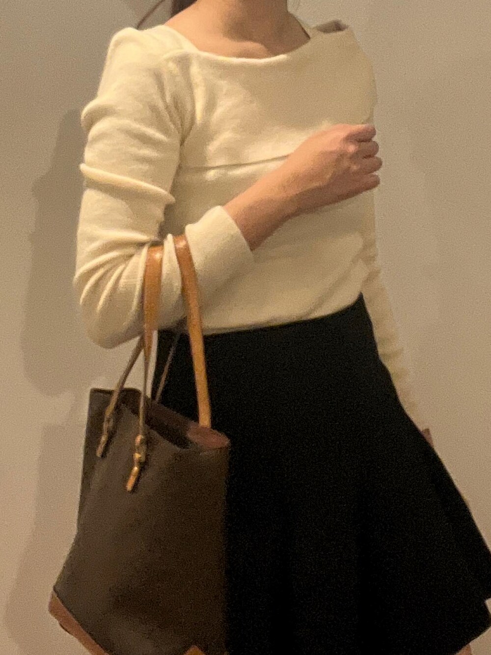 ホワイト系のニット/セーター、ブラック系のスカートを着用したレディースの秋コーディネートの2枚目の写真