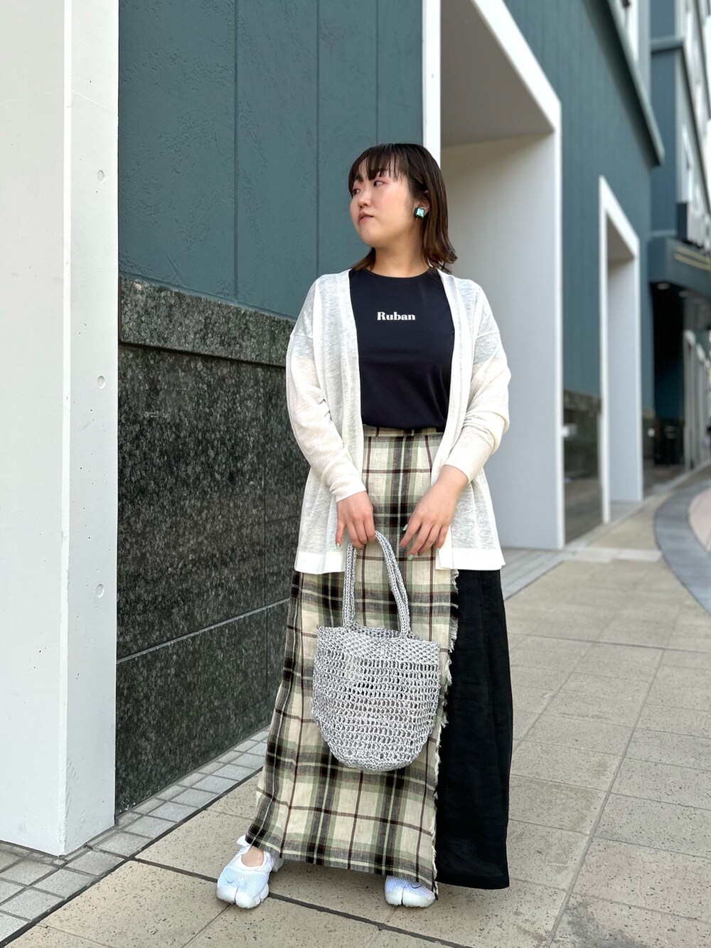 ホワイト系のカーディガン/ボレロ、ブラック系のスカート、シルバー系のバックパック/リュックを着用したレディースの春コーディネートの8枚目の写真