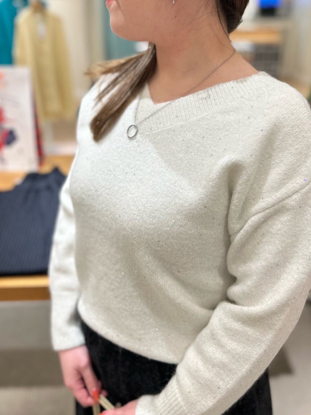 ホワイト系のニット/セーター、ブラック系のスカート、その他のショルダーバッグを着用したレディースの冬コーディネートの7枚目の写真