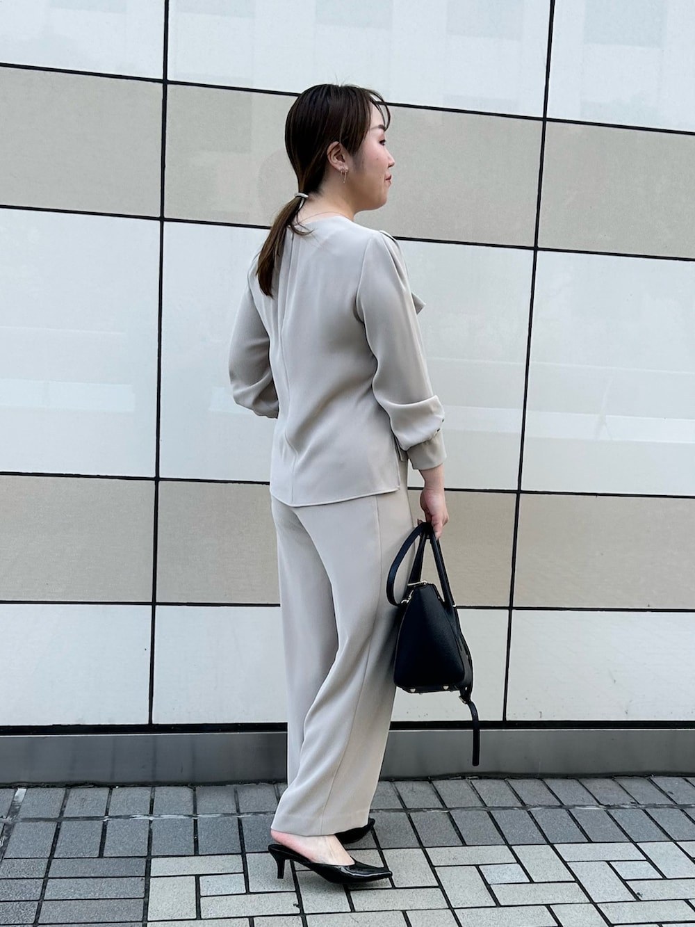ベージュ系のシャツ/ブラウス、ベージュ系のその他パンツ、ブラック系のショルダーバッグを着用したレディースの秋コーディネートの4枚目の写真