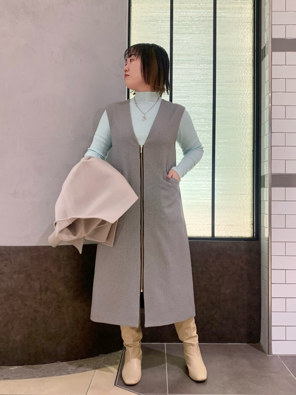 ベージュ系のその他アウター、グレー系のワンピース、グリーン系のニット/セーターを着用したレディースの冬コーディネートの6枚目の写真