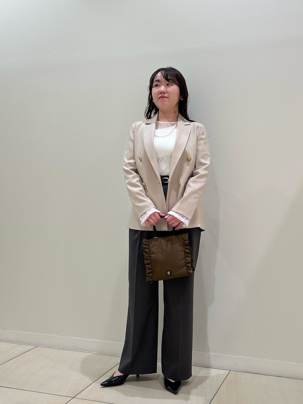 ベージュ系のテーラードジャケット、グレー系のその他パンツ、ホワイト系のTシャツ/カットソーを着用したレディースの春コーディネートの7枚目の写真
