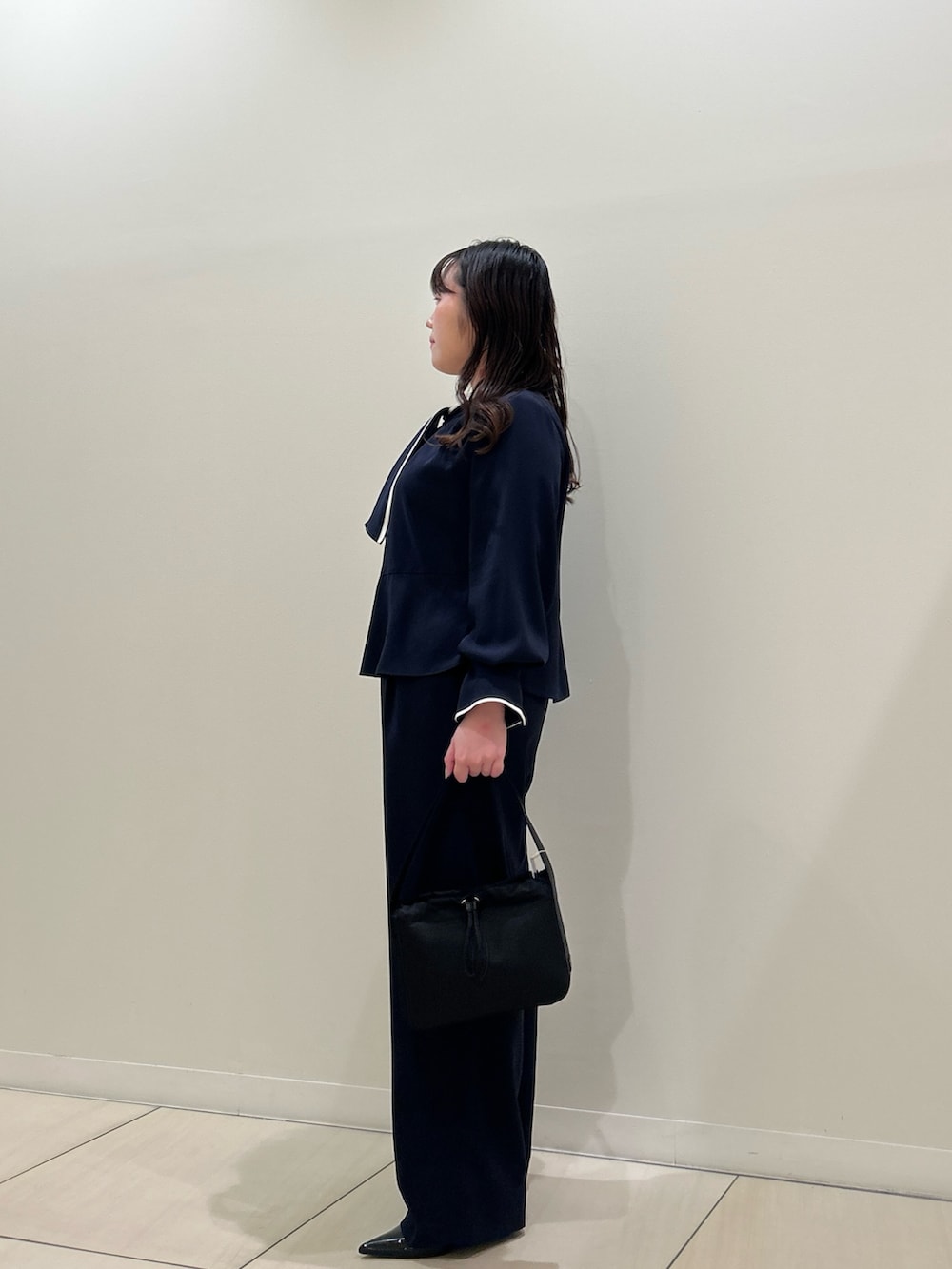 ブルー系のシャツ/ブラウス、ブルー系のその他パンツ、ブラック系のハンドバッグを着用したレディースの春コーディネートの2枚目の写真