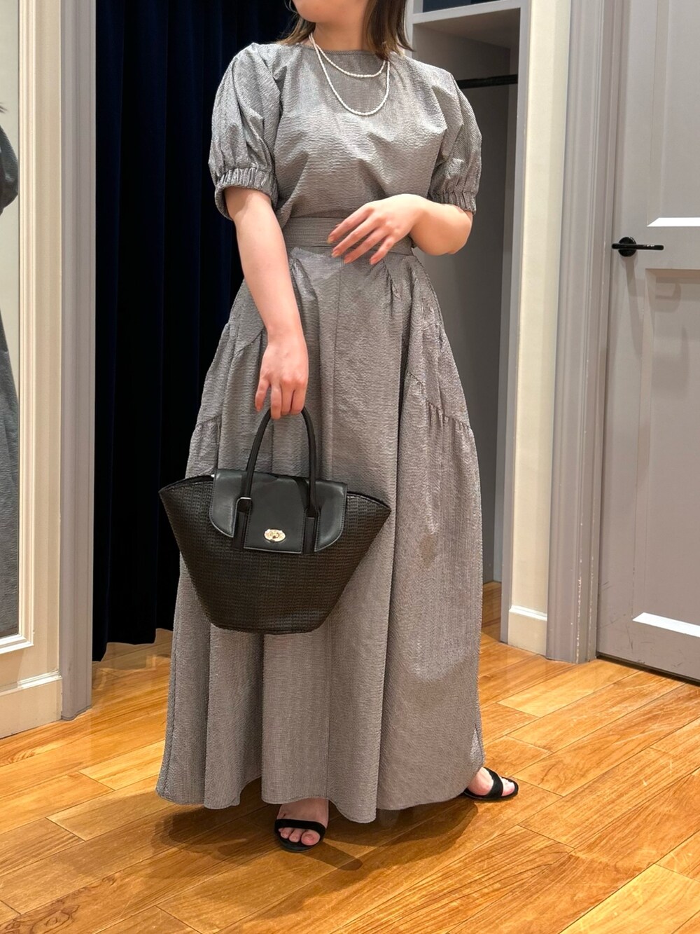 グレー系のシャツ/ブラウス、グレー系のスカート、ブラック系のかごバッグを着用したレディースの夏コーディネートの4枚目の写真