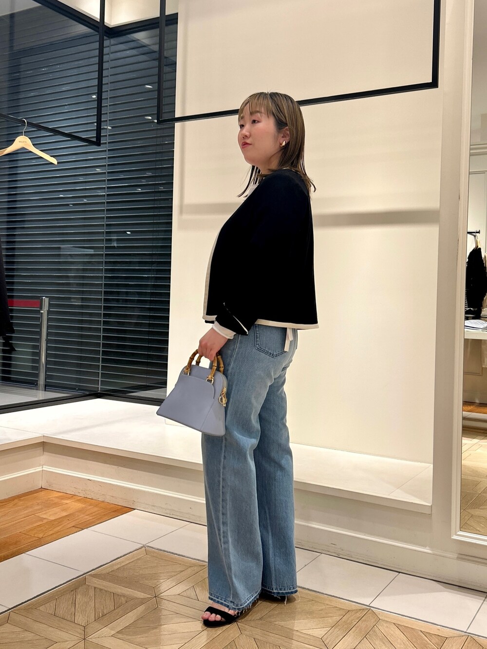 ブラック系のノーカラージャケット、ホワイト系のTシャツ/カットソー、ブルー系のデニムパンツを着用したレディースの冬コーディネートの6枚目の写真