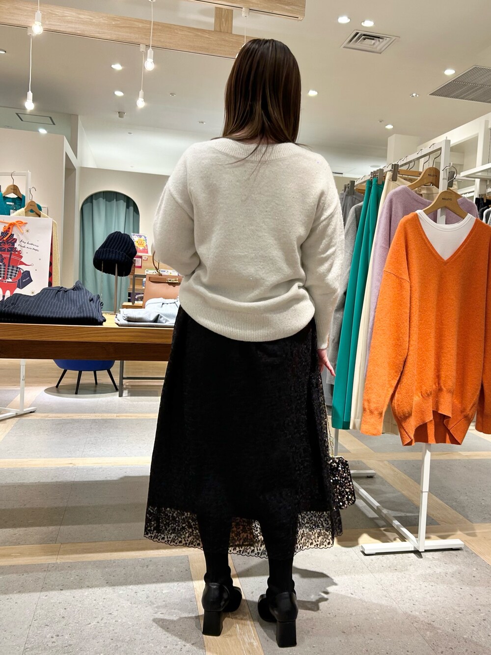 ホワイト系のニット/セーター、ブラック系のスカート、その他のショルダーバッグを着用したレディースの冬コーディネートの3枚目の写真