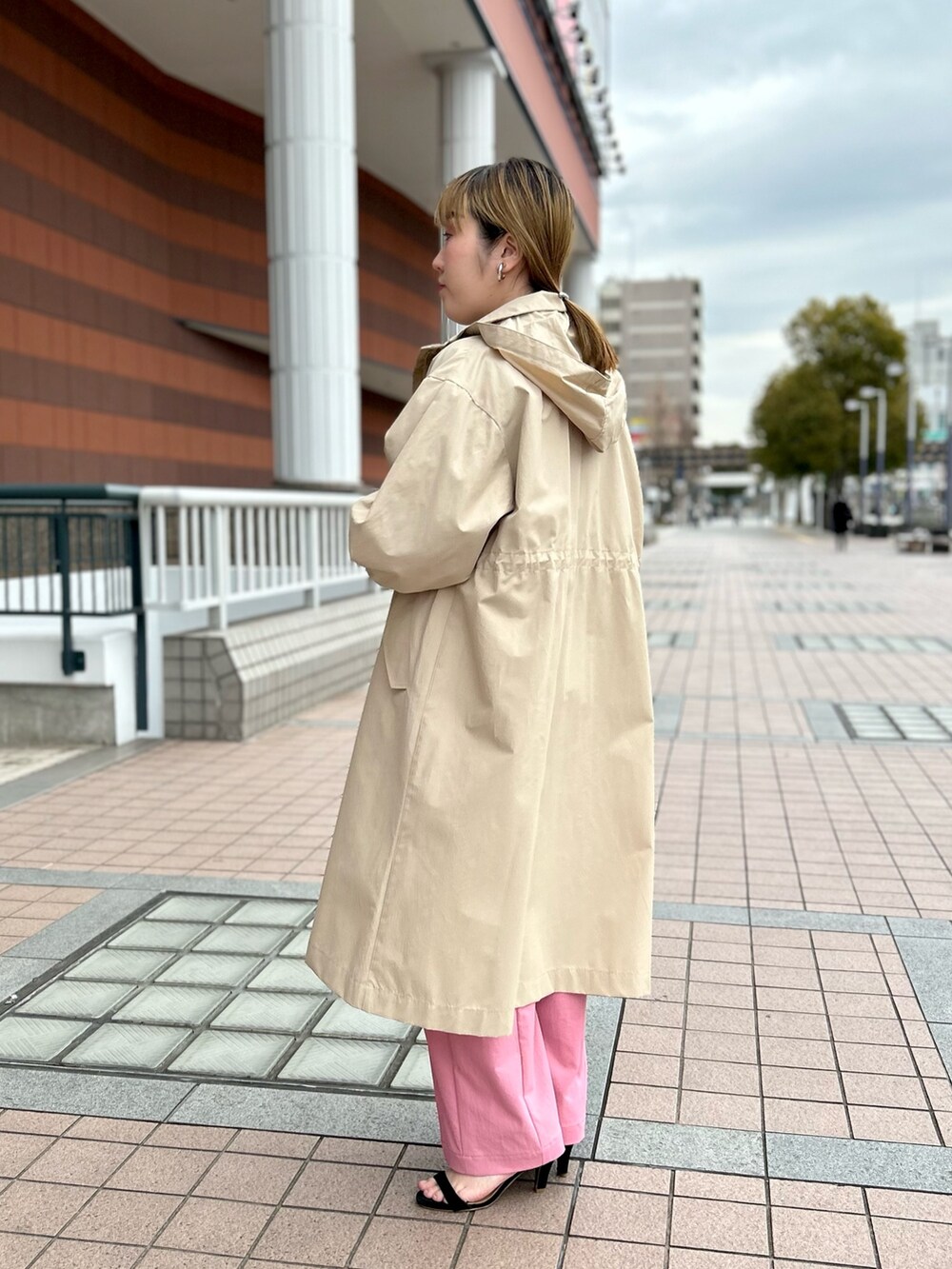 ベージュ系のその他アウター、ブラック系のニット/セーター、ピンク系のチノパンツを着用したレディースの春コーディネートの5枚目の写真