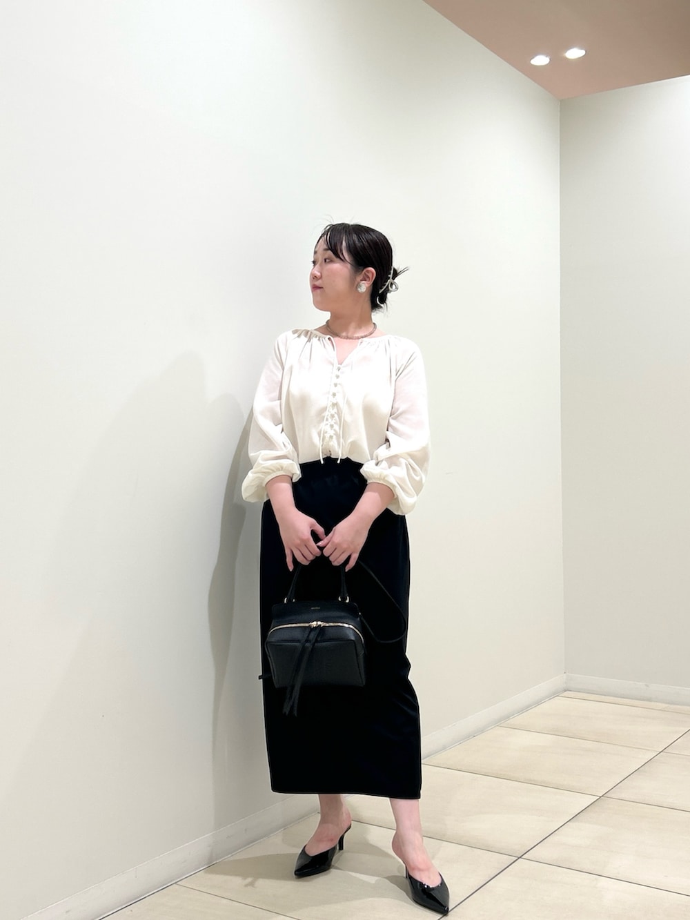 ベージュ系のテーラードジャケット、ホワイト系のシャツ/ブラウス、ブラック系のスカートを着用したレディースの秋コーディネートの6枚目の写真