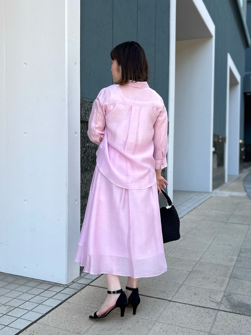ピンク系のシャツ/ブラウス、ピンク系のスカート、ブラック系のショルダーバッグを着用したレディースの春コーディネートの4枚目の写真