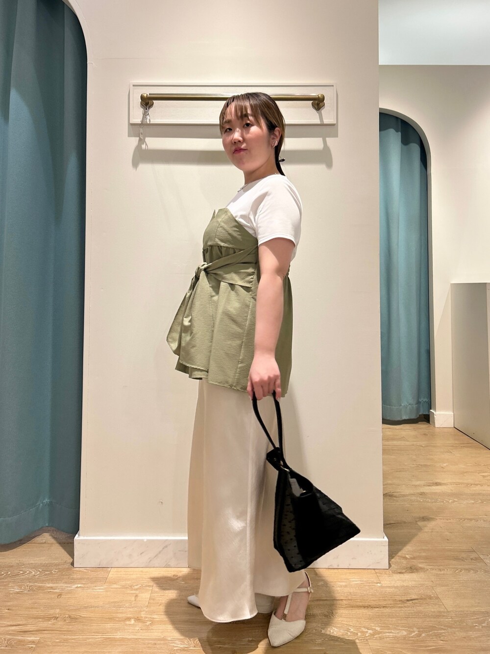 グリーン系のTシャツ/カットソー、ホワイト系のスカート、ブラック系のトートバッグを着用したレディースの夏コーディネートの3枚目の写真