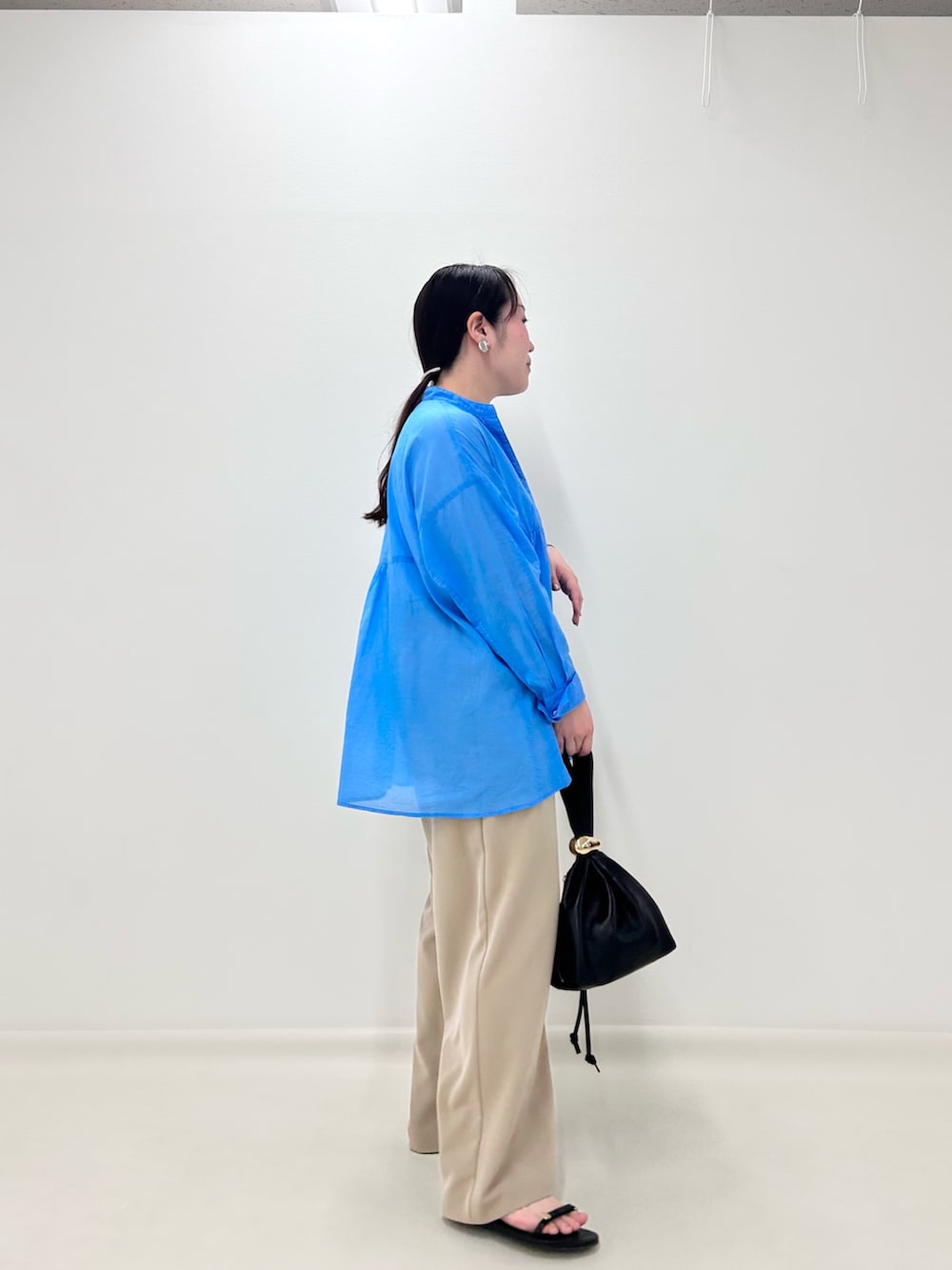 ブルー系のシャツ/ブラウス、ベージュ系のその他パンツ、ブラック系のショルダーバッグを着用したレディースの秋コーディネートの2枚目の写真