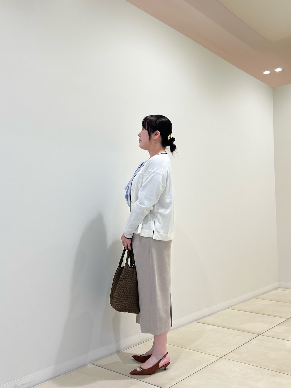 ホワイト系のカーディガン/ボレロ、ブルー系のシャツ/ブラウス、ベージュ系のスカートを着用したレディースの秋コーディネートの2枚目の写真