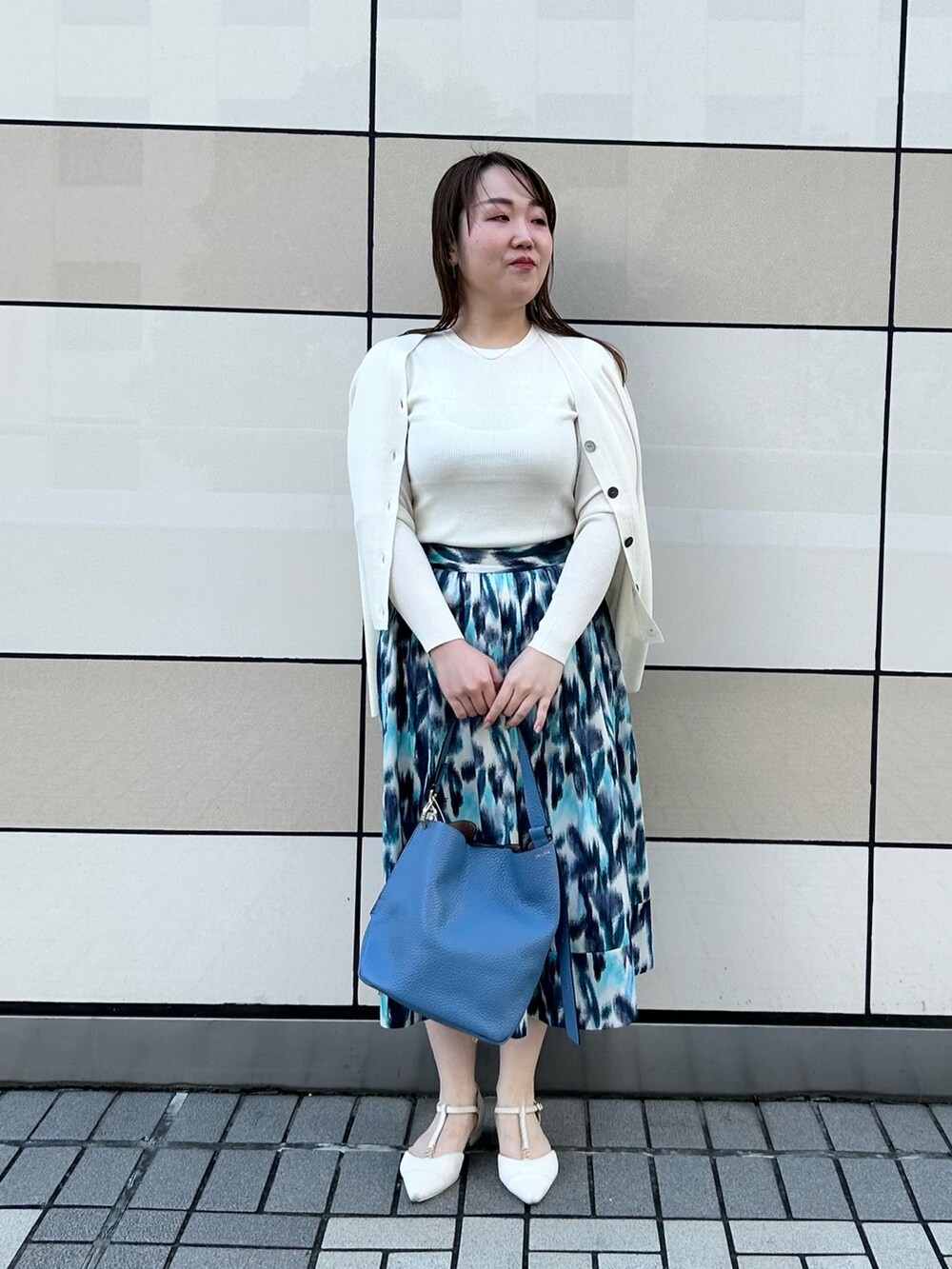 ホワイト系のカーディガン/ボレロ、ホワイト系のニット/セーター、ブルー系のスカートを着用したレディースの秋コーディネートの5枚目の写真
