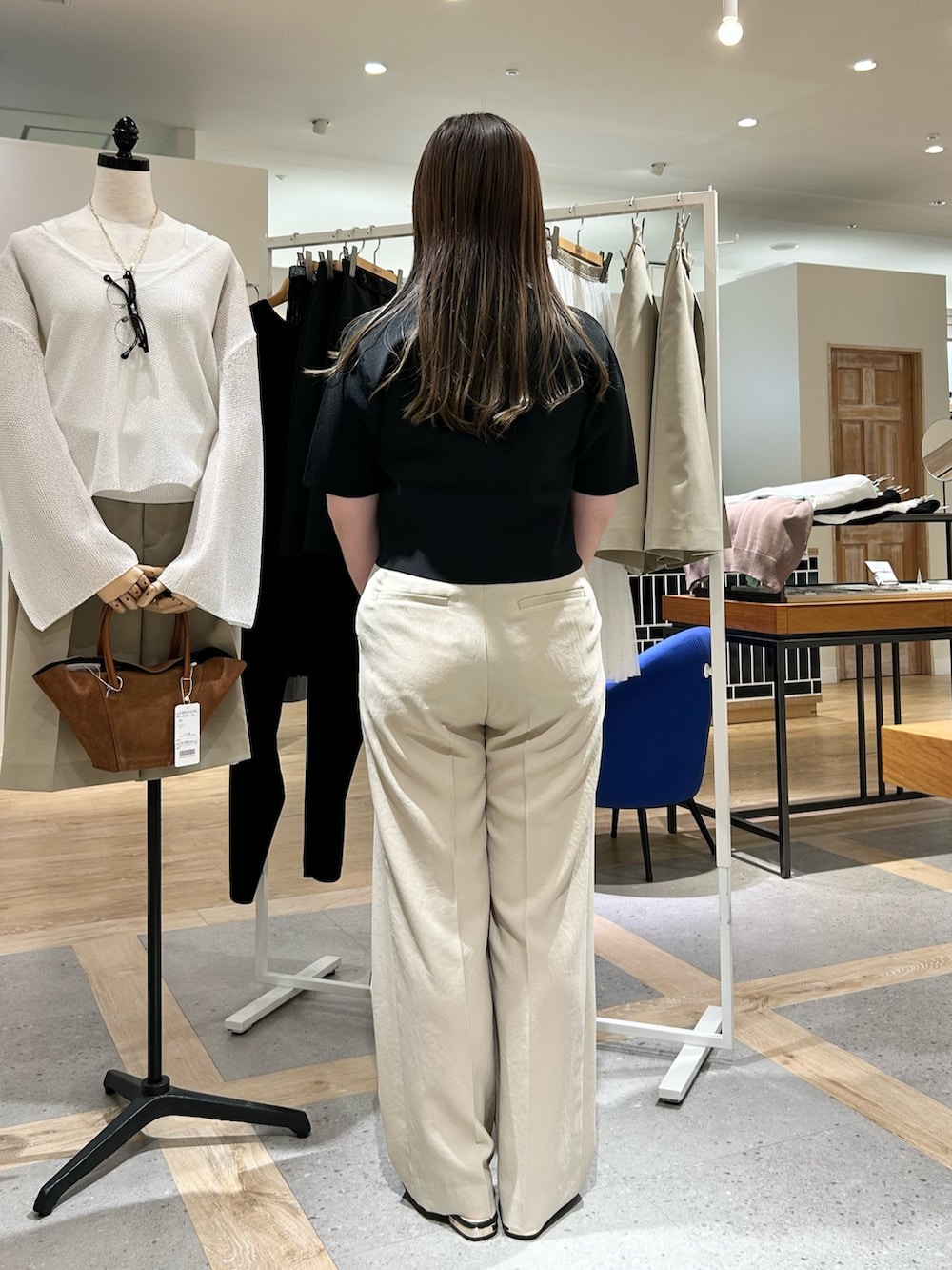 ブラック系のノーカラージャケット、ベージュ系のその他パンツ、ホワイト系のショルダーバッグを着用したレディースの夏コーディネートの3枚目の写真