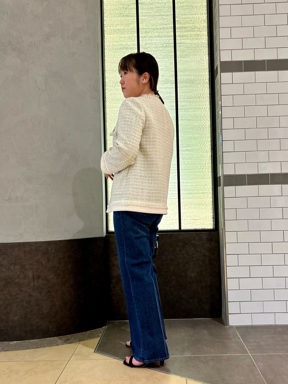 ホワイト系のノーカラージャケット、ブラック系のTシャツ/カットソー、ブルー系のデニムパンツを着用したレディースの夏コーディネートの8枚目の写真