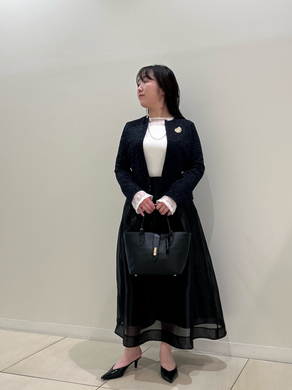 ブルー系のノーカラージャケット、ブラック系のスカート、ホワイト系のTシャツ/カットソーを着用したレディースの春コーディネートの9枚目の写真