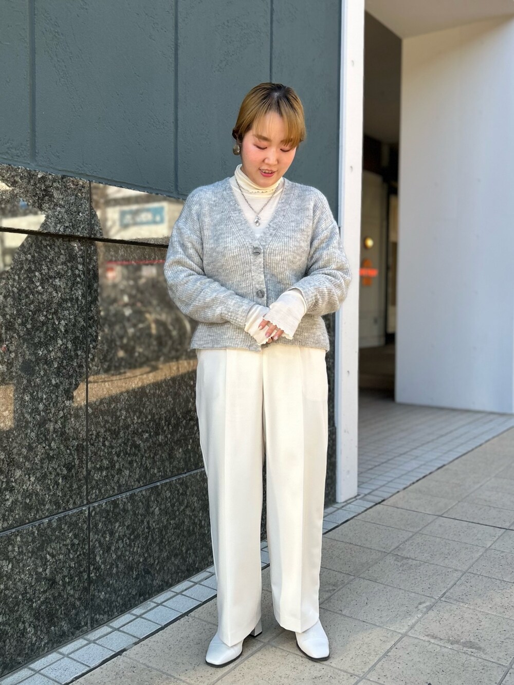 グレー系のカーディガン/ボレロ、ホワイト系のTシャツ/カットソー、ホワイト系のその他パンツを着用したレディースの冬コーディネートの2枚目の写真